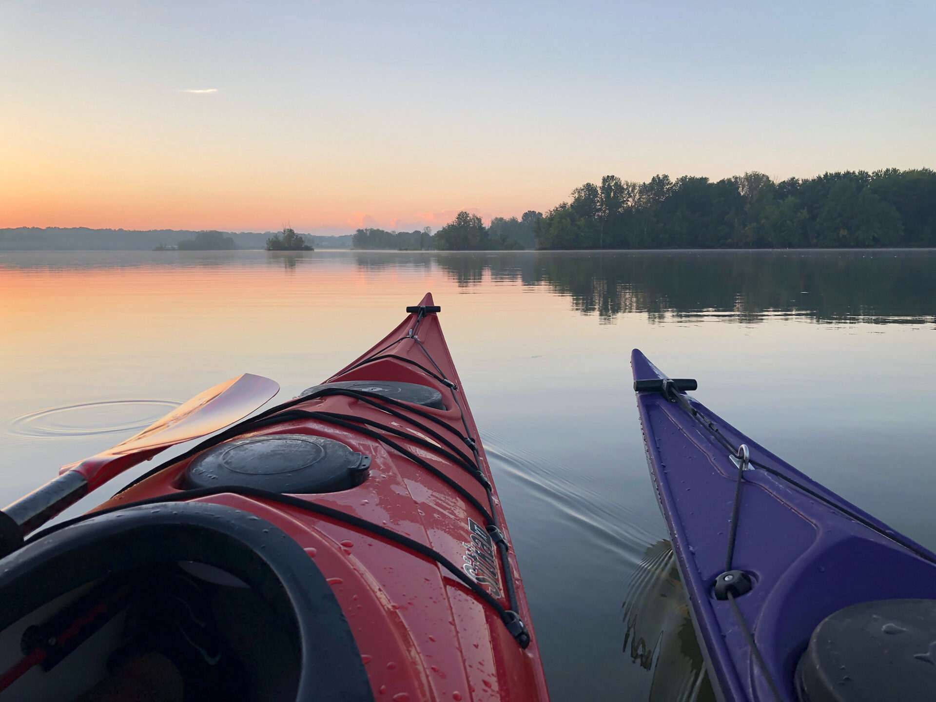 Two kayaks side by side at sunrise