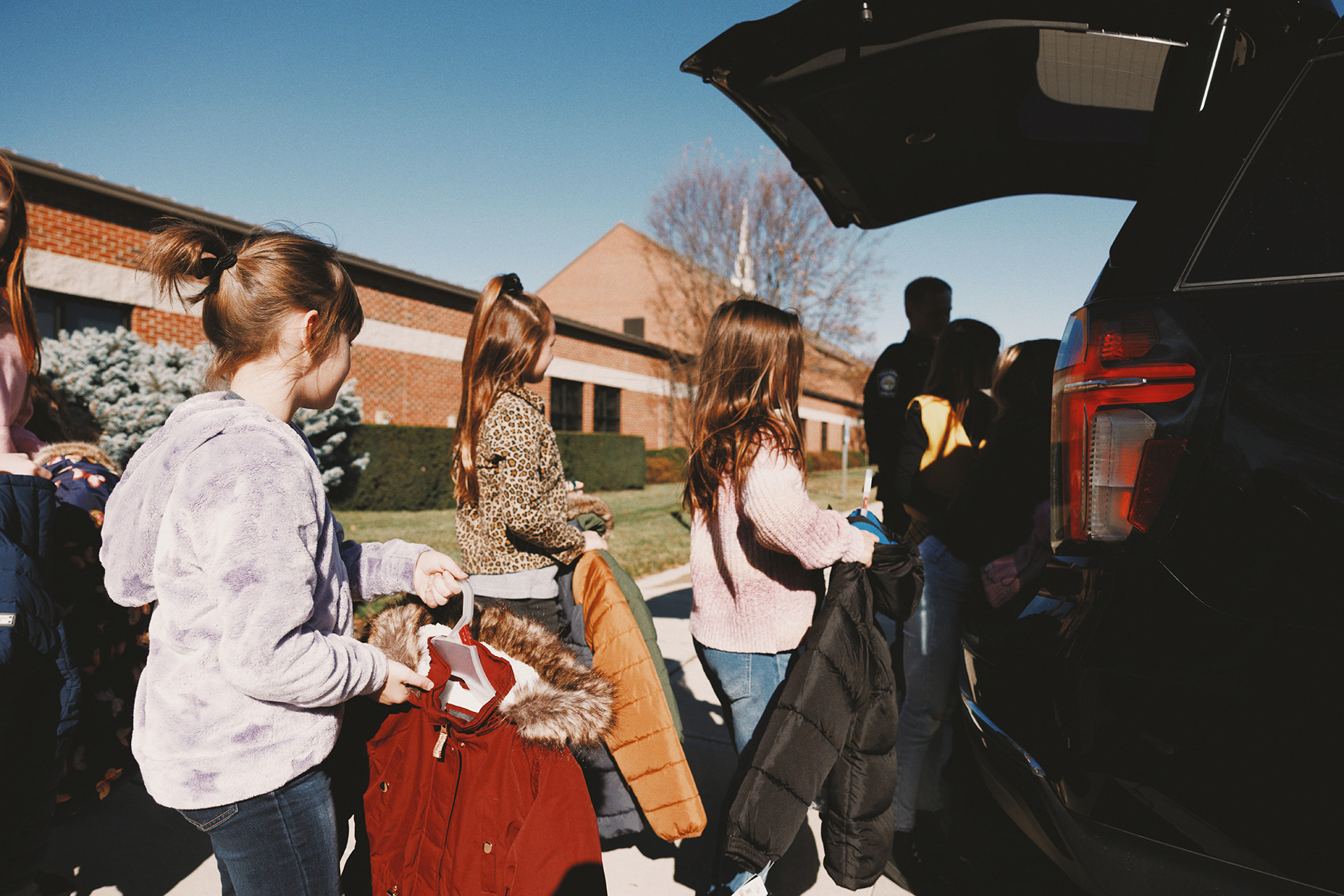 Children loading a Hilliard Police cruiser with new coats for needy kids.