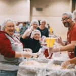 Smiling group packing meals together.