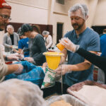 Families packing meals together.
